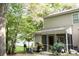 Back of house shows a screened-in patio with potted plants, greenery, and an outdoor seating area at 107 Twin Tree Dr, Summerville, SC 29485
