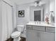 Well-lit bathroom features a gray vanity with modern fixtures and a shower with white curtain at 110 Bloomfield St, Summerville, SC 29486