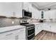 Well-appointed kitchen with stainless steel appliances, white cabinetry, and tile backsplash with hardwood flooring at 110 Bloomfield St, Summerville, SC 29486