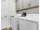 This laundry room has side by side washer and dryer units with gray cabinets above at 110 Bloomfield St, Summerville, SC 29486