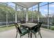 This is a screened in porch with black metal chairs and a small, dark table at 110 Bloomfield St, Summerville, SC 29486
