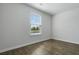 Bright bedroom featuring a window with view of lush outdoors and dark wood-look flooring at 125 Mims Academy Dr, Harleyville, SC 29448