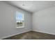 A brightly lit bedroom with a window that allows natural light to enter, showing the flooring at 125 Mims Academy Dr, Harleyville, SC 29448