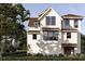Charming two-story home with a gabled roof, light siding, large windows and meticulously landscaped front yard at 13 Trumbo St, Charleston, SC 29401