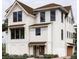 Elegant three-story home boasts a mix of white siding and brick, dark windows, and a well-manicured front garden at 13 Trumbo St, Charleston, SC 29401