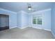 Bedroom with plush carpet, a ceiling fan, and a large window, plus hardwood entry from hall at 1319 Basildon Rd, Mount Pleasant, SC 29466