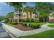 Exterior view showcasing yellow siding, lush landscaping, palm trees, and a well-maintained sidewalk at 1319 Basildon Rd, Mount Pleasant, SC 29466