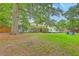 Spacious backyard featuring a well-maintained lawn, mature trees, and a cozy deck area for outdoor enjoyment at 1350 Mosstree Rd, North Charleston, SC 29405