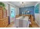 Elegant dining room with modern light fixture, blue accent wall, and hardwood floors at 1350 Mosstree Rd, North Charleston, SC 29405