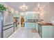 Charming kitchen with mint cabinets, stainless steel appliances, butcher block counters, and tile flooring at 1350 Mosstree Rd, North Charleston, SC 29405