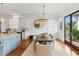 Dining area adjacent to the kitchen features a wooden table, neutral chairs, and modern lighting at 158 Mary Ellen Dr, Charleston, SC 29403