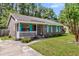Charming single-story brick home featuring a covered porch, vibrant shutters, and a well-manicured front yard at 202 Pamela Ln, Summerville, SC 29483