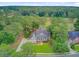 Aerial view of a well-maintained home with a manicured lawn near a golf course, surrounded by a lush forest at 204 Bellerive Ln, Summerville, SC 29483