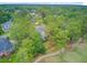 Aerial view of a house bordering a golf course, partially obscured by lush trees in a residential neighborhood at 204 Bellerive Ln, Summerville, SC 29483
