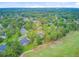 Aerial view showcasing a residential area with houses interspersed among lush green trees and a nearby golf course at 204 Bellerive Ln, Summerville, SC 29483