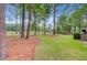 Expansive backyard featuring mature trees, lush greenery, and view of the golf course beyond at 204 Bellerive Ln, Summerville, SC 29483