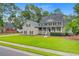 Charming home with a manicured lawn, mature trees, and a welcoming front porch at 204 Bellerive Ln, Summerville, SC 29483