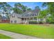 Beautiful home with a well-kept lawn, mature trees, and classic architectural details at 204 Bellerive Ln, Summerville, SC 29483