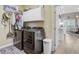 Modern laundry room with sleek washer/dryer units, white cabinets, and a view of the kitchen at 204 Bellerive Ln, Summerville, SC 29483