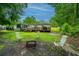 A backyard featuring a fire pit, chairs, and a lush lawn surrounded by mature trees at 204 Pete Ewers Dr, Summerville, SC 29483