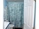 Bright bathroom with a patterned shower curtain, white fixtures, and storage shelving, providing a clean and functional space at 204 Pete Ewers Dr, Summerville, SC 29483