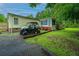 The exterior of the home featuring the sunroom and a green utility vehicle parked in the yard at 204 Pete Ewers Dr, Summerville, SC 29483
