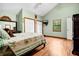 Bright bedroom with hardwood floors, a tv, view to the trees, and a vaulted ceiling at 209 Jungle Rd, Edisto Beach, SC 29438