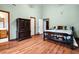 Bedroom with wood floors, bed, and dark wood dresser with adjacent bathroom and closet doors at 209 Jungle Rd, Edisto Beach, SC 29438