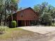 Charming raised home with wood siding, a striking orange door, ample parking, and surrounded by picturesque greenery at 209 Jungle Rd, Edisto Beach, SC 29438