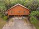 Exterior of stilt home with wood siding, ample parking underneath, and a brick driveway, combining charm and practicality at 209 Jungle Rd, Edisto Beach, SC 29438