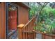 Exterior view of front door with wood porch and stairs surrounded by lush foliage at 209 Jungle Rd, Edisto Beach, SC 29438