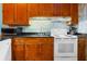 Kitchen featuring wood cabinets, black countertops, and white appliances at 209 Jungle Rd, Edisto Beach, SC 29438