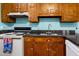 Compact kitchen featuring wood cabinets, black and white appliances, and dark countertops at 209 Jungle Rd, Edisto Beach, SC 29438