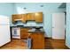 Kitchen with blue walls, wood cabinets, white fridge and stove with granite countertop and black sink at 209 Jungle Rd, Edisto Beach, SC 29438