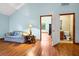 Living room with hardwood floors, sofa and doorway leading to a bathroom at 209 Jungle Rd, Edisto Beach, SC 29438