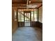 Bare screened in porch with wood frame showing the cement floor, ceiling fan, and access door at 209 Jungle Rd, Edisto Beach, SC 29438