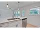 Kitchen island with white cabinets, quartz countertop, stainless steel dishwasher, and pendant lighting at 2135 Clayton St, Charleston, SC 29414