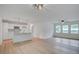 Bright living area with white walls, wood floors, ceiling fan and an open view to the kitchen at 2135 Clayton St, Charleston, SC 29414