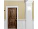 Stylish wood front door with white trim and wall-mounted sconce in a condo building hallway at 2244 Ashley Crossing Dr # 534, Charleston, SC 29414