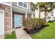 Close-up of the home's light blue front door, stone facade, manicured shrubs, and green lawn at 228 Donatella Dr, Goose Creek, SC 29445