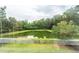 Backyard view of a pond surrounded by green trees and a wooden fence at 228 Donatella Dr, Goose Creek, SC 29445
