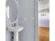 Modern half bathroom features a white pedestal sink and decorative mirror at 230 Darcy Ave, Goose Creek, SC 29445