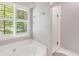 Spa-like bathroom featuring a soaking tub, walk-in shower, and plantation shutters at 261 Mossy Oak Way, Mount Pleasant, SC 29464