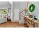 Open foyer featuring staircase with greenery, leading to living room with large window and wood floors at 261 Mossy Oak Way, Mount Pleasant, SC 29464