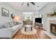Open-concept living room featuring fireplace, ceiling fan, light gray walls, and opening to the dining area at 261 Mossy Oak Way, Mount Pleasant, SC 29464