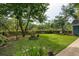 Large, well-maintained backyard with green grass, mature trees, and manicured landscaping at 2900 Split Hickory Ct, Johns Island, SC 29455