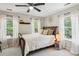 Bedroom with a wooden sleigh bed, two windows with sheer curtains, and a ceiling fan at 2900 Split Hickory Ct, Johns Island, SC 29455