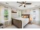 Bedroom with three windows dressed in sheer curtains plus a sleigh bed and ceiling fan at 2900 Split Hickory Ct, Johns Island, SC 29455