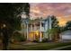 Charming two-story home with a double porch and manicured landscaping at sunset at 2900 Split Hickory Ct, Johns Island, SC 29455