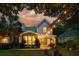 Twilight view of a cozy home with backyard string lights, lush greenery, and a mature palm at 2900 Split Hickory Ct, Johns Island, SC 29455